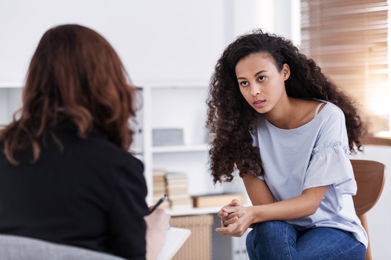 Two women talking supportively in a bright room
